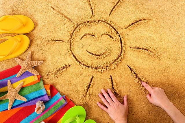 Sonne im Sand gezeichnet